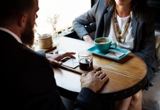 Professional services business owner meeting their accountant in a cafe