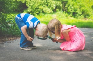 Two toddlers using magnifying glasses