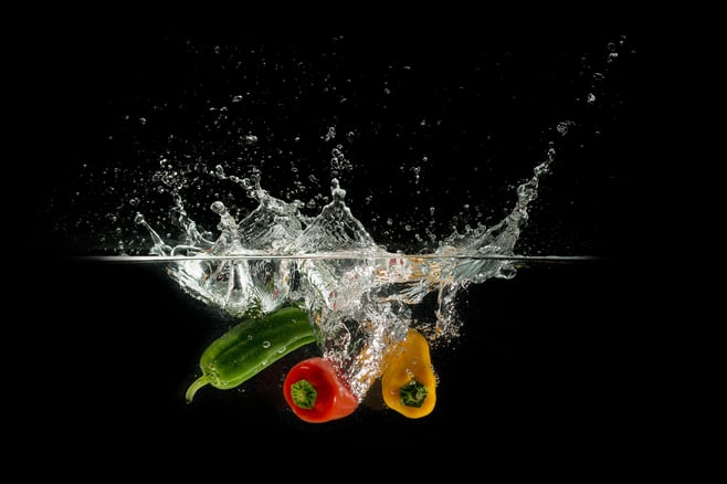 Peppers being dropped into water