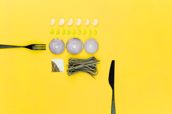 Knife and Fork with onions, garlic, pasta, salt and pepper